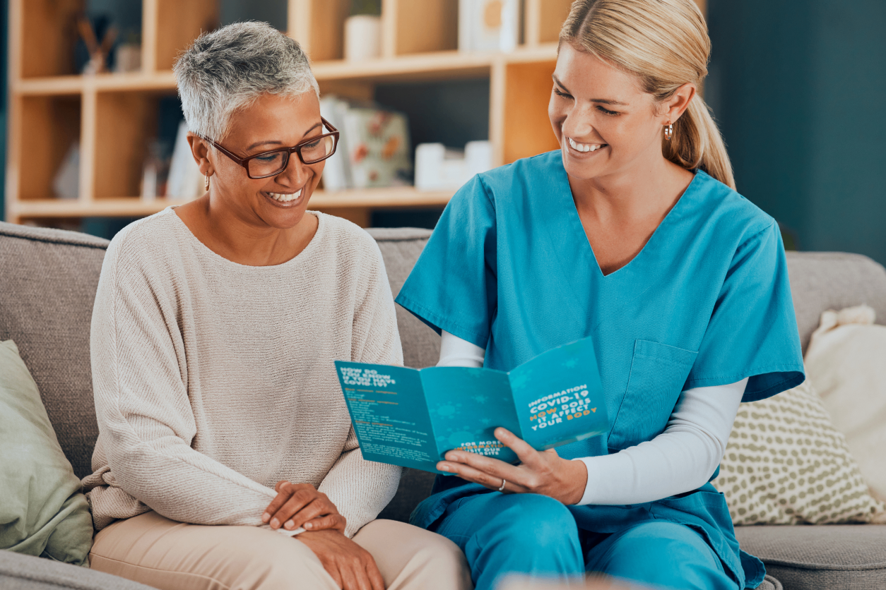 A healthcare worker explaining information to a senior woman.